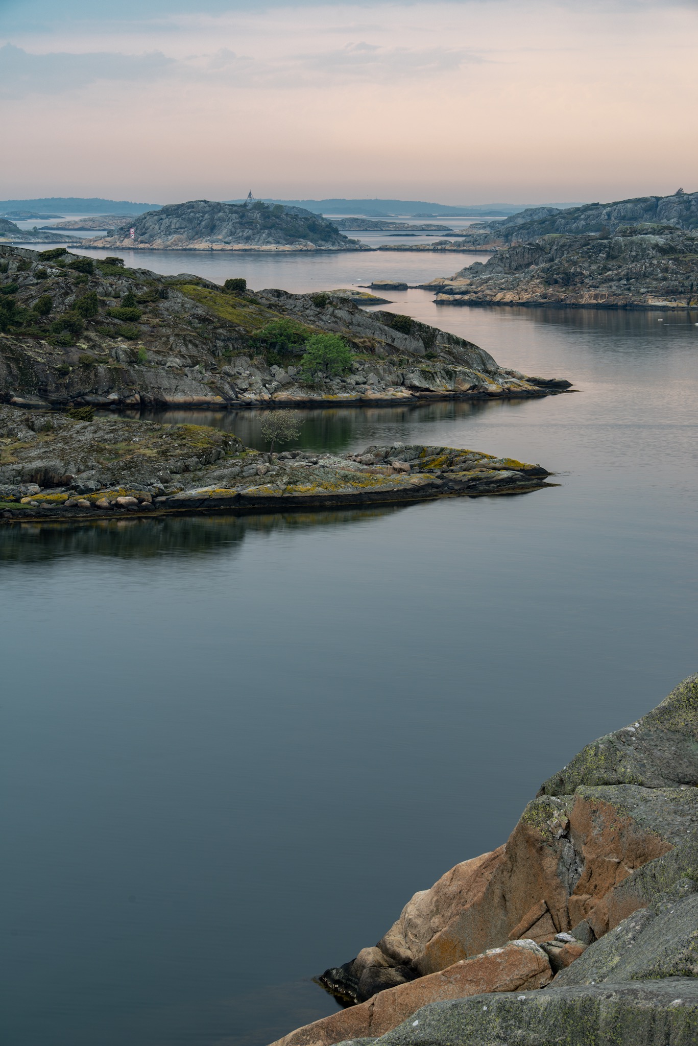 Klippöar och lugnt vatten i Billdals skärgård i kvällsljus